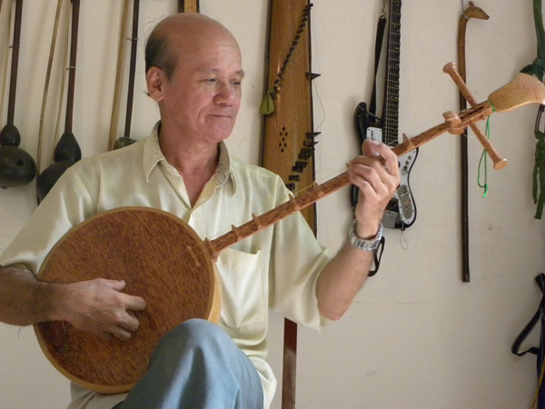 Ông Võ Văn Bá với chiếc đàn được làm từ cây dừa. Ảnh: Đức Thịnh. Ông Võ Văn Bá với chiếc đàn được làm từ cây dừa. Ảnh: Đức Thịnh