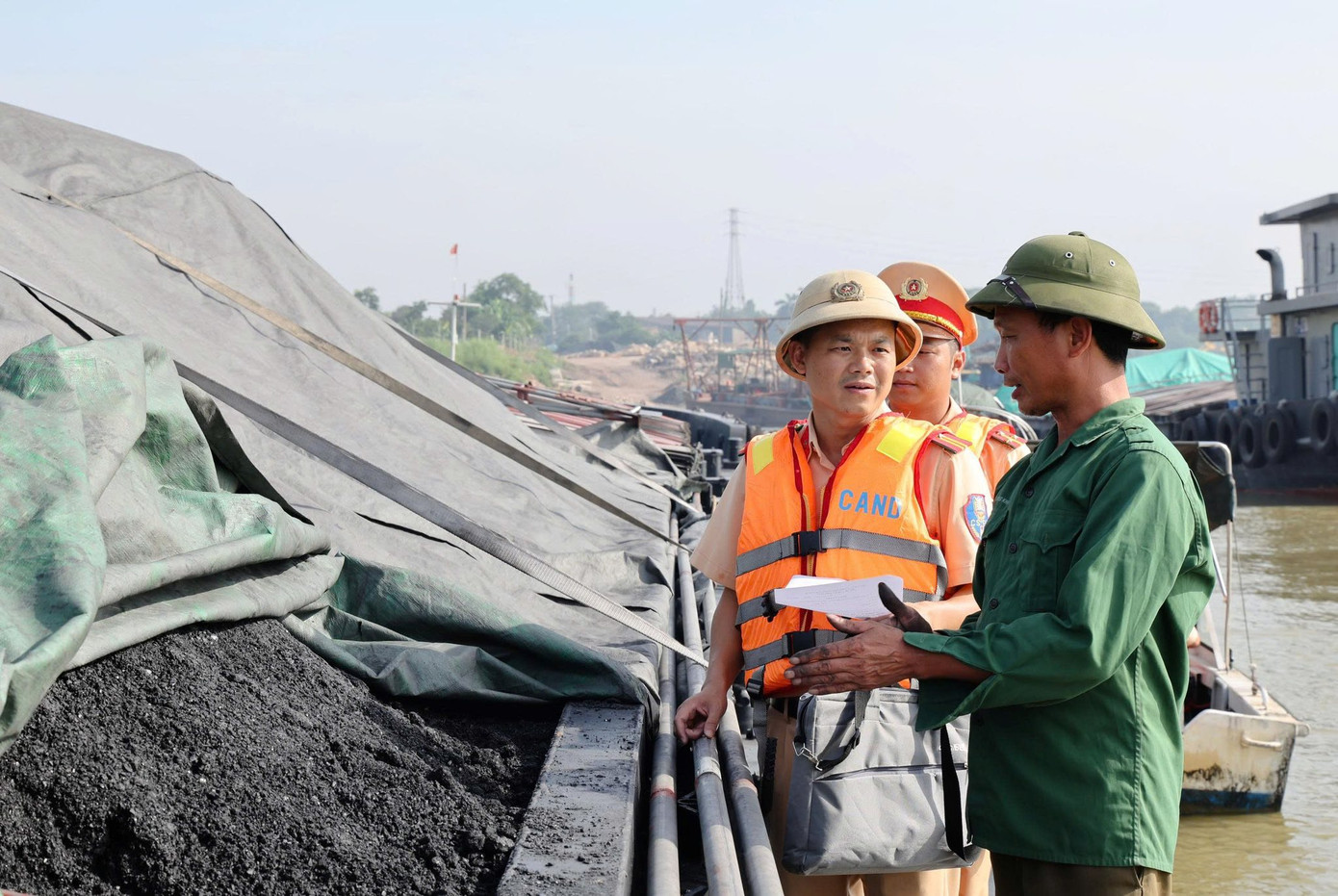 Cảnh sát giao thông kiểm tra phương tiện vận chuyển than trên sông Hồng.