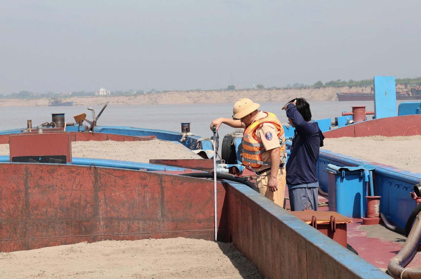 Cảnh sát giao thông kiểm tra phương tiện vận chuyển cát.