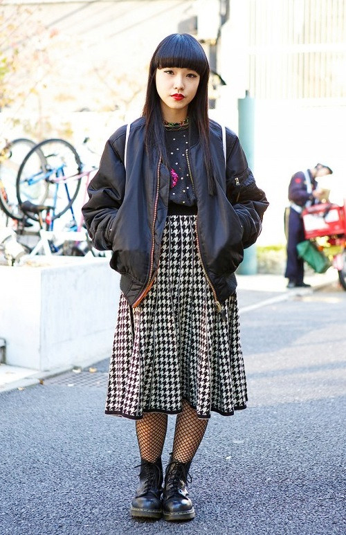 Đây là một phong cách cực chuẩn thường thấy ở phố Harajuku. Áo bomber jacket và len đen đính kim sa được Chipa (20 tuổi) phối cùng váy họa tiết răng cưa, tất lưới và giày Dr. Martens