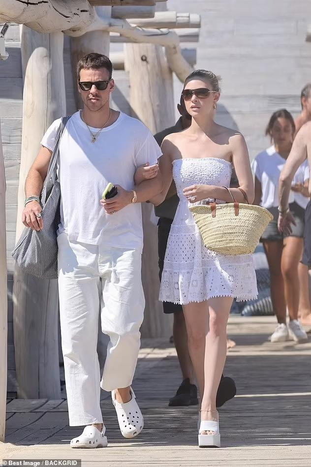 Nicola diện váy quây màu trắng "ton-sur-ton" với chồng, có giá hơn 10 triệu đồng. Thêm đôi giày cao gót "khủng", túi cói và kính đen, ái nữ nhà tỷ phú Nelson Peltz toát lên vẻ đẹp nữ tính, yêu kiều. Thân hình mảnh mai cùng làn da trắng mịn màng khiến nhiều cô gái ghen tỵ.