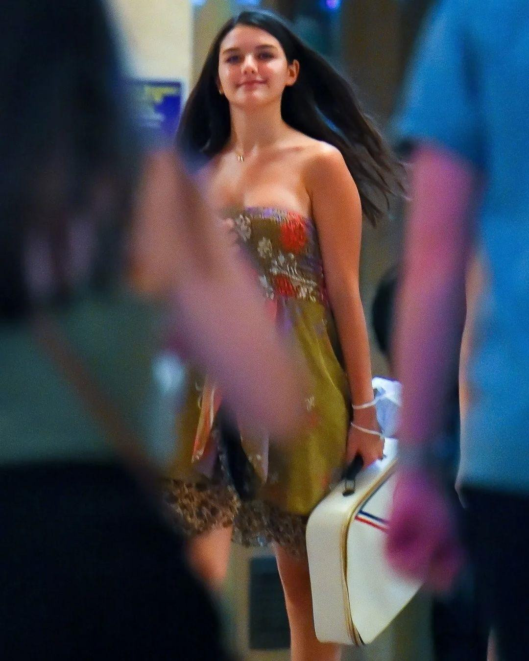 Suri mặc váy quây màu xanh họa tiết hoa tôn lên vóc dáng thiếu nữ ngày càng phổng phao. Cùng với mái tóc dài buông xõa, "Tiểu công chúa Hollywood" một thời trông dịu dàng, nữ tính và rất thu hút.