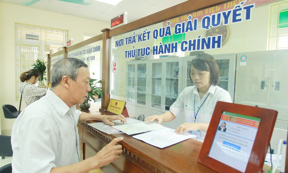 Cán bộ, công chức cấp xã/phường hướng dẫn người dân làm thủ tục hành chính Cán bộ, công chức cấp xã/phường hướng dẫn người dân làm thủ tục hành chính