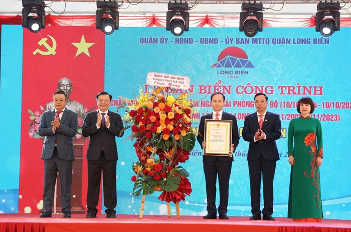 Bí thư Thành ủy Đinh Tiến Dũng và Chủ tịch UBND Thành phố Trần Sỹ Thanh trao bằng chứng nhận, tặng hoa chúc mừng quận Long Biên