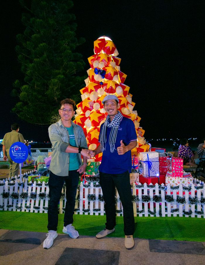 Anh Nguyễn Hồ (bên phải), tác giả của cây thông nón lá chia sẻ: "Cây thông nón lá là một tác phẩm nằm trong chuỗi sự kiện "Santa Run Vũng Tàu 2022" được diễn ra vào chiều tối ngày 24/12, do UBND Thành phố Vũng Tàu kết hợp Nhà văn hóa Thanh Niên tỉnh Bà Rịa-Vũng Tàu tổ chức. Cây thông được tạo nên để phục vụ người dân, du khách tham quan, chụp ảnh hoàn toàn miễn phí" (Ảnh: Quang Thành)