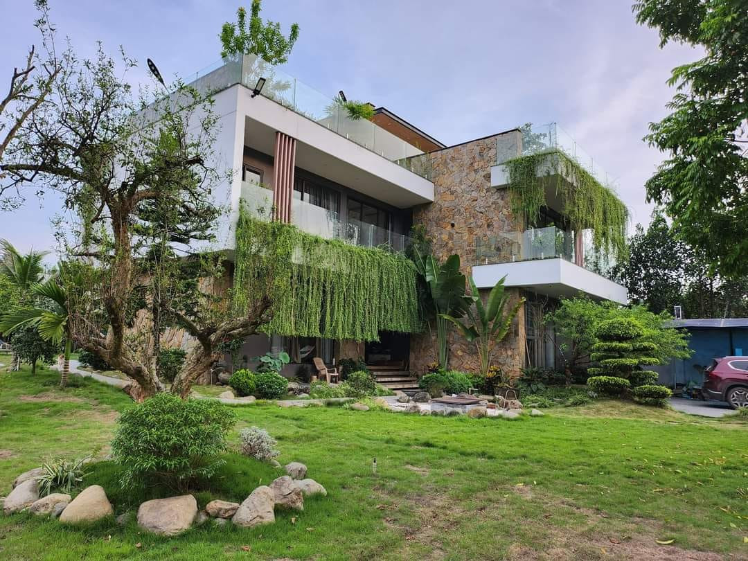 Tường đá màu vàng bao quanh một phần căn biệt thự. Tường đá màu vàng bao quanh một phần căn biệt thự.