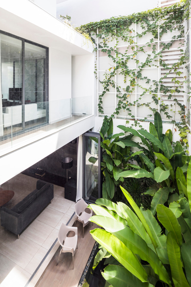 Khu vườn phía sau kết hợp với giàn dây leo khiến khu vực tầng trệt gần gũi với thiên nhiên hơn.