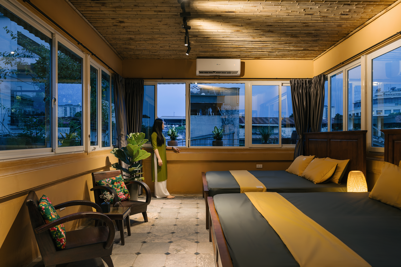 Ánh sáng vàng mang hơi thở nghỉ dưỡng kết hợp nội thất gỗ và sơn tường màu vàng giúp không gian thêm ấm cúng, thư giãn và dễ chịu.