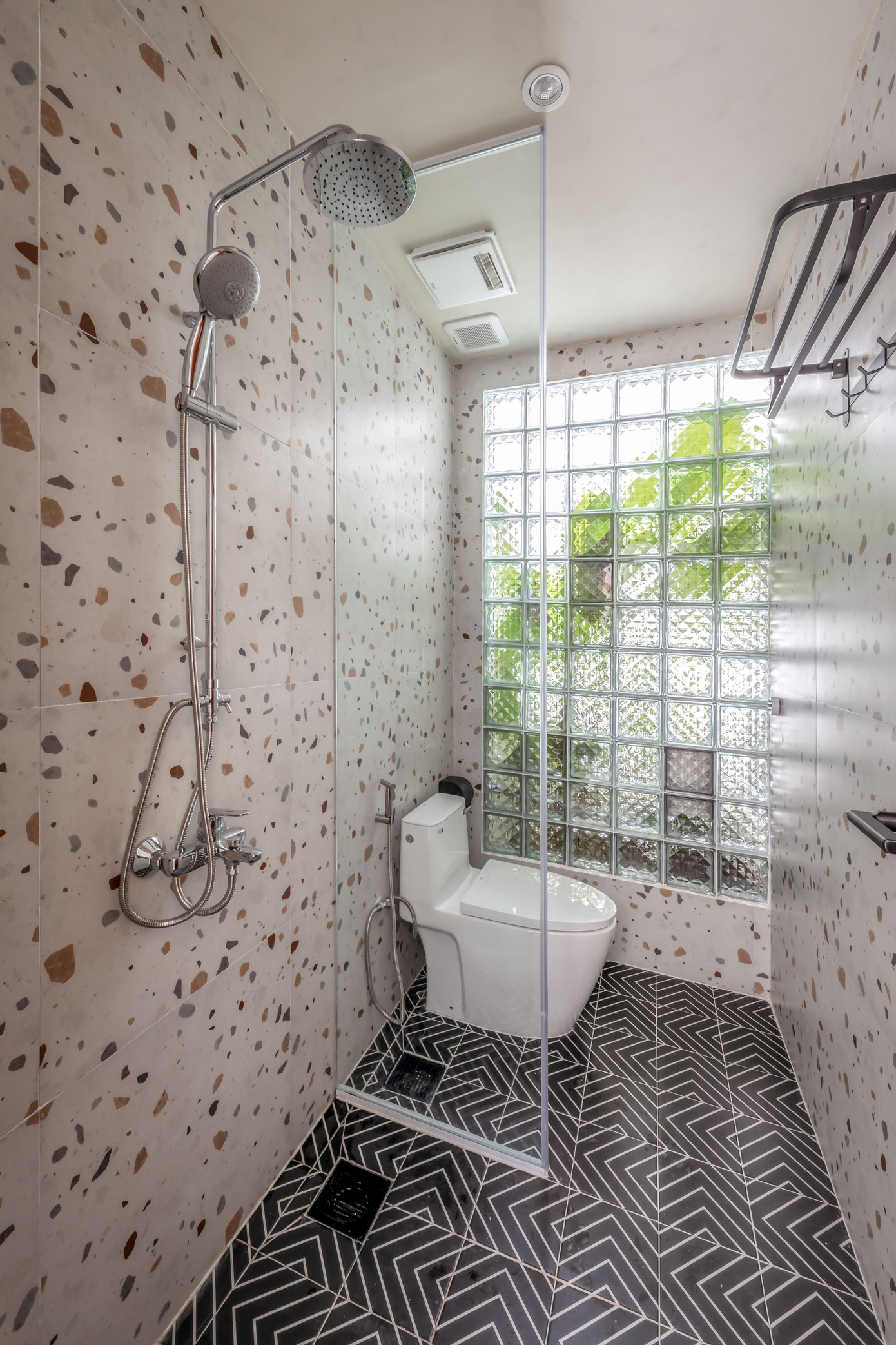 Phòng tắm nhỏ nhắn nhưng vẫn hiện đại, tận dụng ánh sáng bên ngoài thông qua những ô cửa kính vuông vắn.