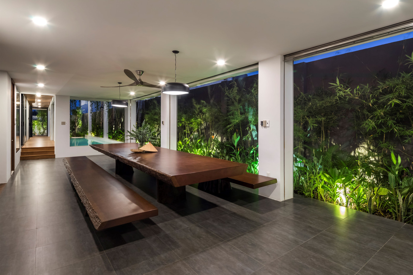 Bàn ăn có tầm nhìn hướng ra bể bơi và sân vườn, giúp bữa ăn thêm ngon miệng.