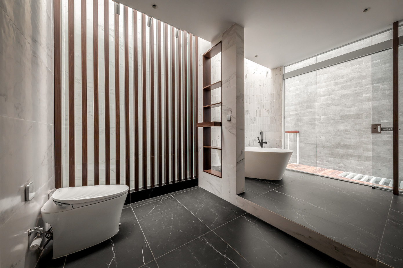 Phòng vệ sinh hiện đại với bồn tắm và khu vực vệ sinh được ngăn cách.