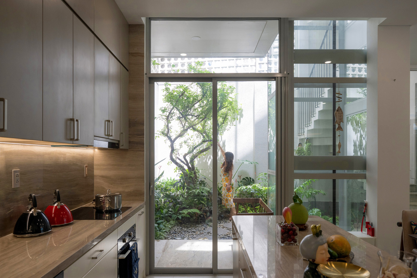 Không gian nội thất của ngôi nhà được thiết kế thoáng đãng, trong suốt và ngập tràn ánh sáng. Có một khu vườn bí mật với một cây sơ-ri lớn và nhiều loài cây cỏ thoắt ẩn thoắt hiện ở góc xa nhất của khu đất. Khu vườn bí mật đưa những vệt nắng dịu nhẹ cùng những làn gió mát lành vào đến trung tâm của ngôi nhà trong khi vẫn đảm bảo tính an ninh và riêng tư nhờ vào các bức tường rào xây gạch lỗ trang trí. Không gian nội thất của ngôi nhà được thiết kế thoáng đãng, trong suốt và ngập tràn ánh sáng. Có một khu vườn bí mật với một cây sơ-ri lớn và nhiều loài cây cỏ thoắt ẩn thoắt hiện ở góc xa nhất của khu đất. Khu vườn bí mật đưa những vệt nắng dịu nhẹ cùng những làn gió mát lành vào đến trung tâm của ngôi nhà trong khi vẫn đảm bảo tính an ninh và riêng tư nhờ vào các bức tường rào xây gạch lỗ trang trí.