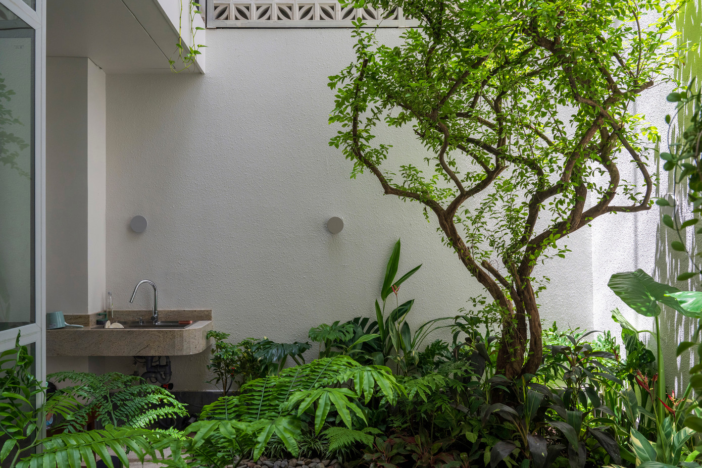 Không gian nội thất của ngôi nhà được thiết kế thoáng đãng, trong suốt và ngập tràn ánh sáng. Có một khu vườn bí mật với một cây sơ-ri lớn và nhiều loài cây cỏ thoắt ẩn thoắt hiện ở góc xa nhất của khu đất. Khu vườn bí mật đưa những vệt nắng dịu nhẹ cùng những làn gió mát lành vào đến trung tâm của ngôi nhà trong khi vẫn đảm bảo tính an ninh và riêng tư nhờ vào các bức tường rào xây gạch lỗ trang trí. Không gian nội thất của ngôi nhà được thiết kế thoáng đãng, trong suốt và ngập tràn ánh sáng. Có một khu vườn bí mật với một cây sơ-ri lớn và nhiều loài cây cỏ thoắt ẩn thoắt hiện ở góc xa nhất của khu đất. Khu vườn bí mật đưa những vệt nắng dịu nhẹ cùng những làn gió mát lành vào đến trung tâm của ngôi nhà trong khi vẫn đảm bảo tính an ninh và riêng tư nhờ vào các bức tường rào xây gạch lỗ trang trí.