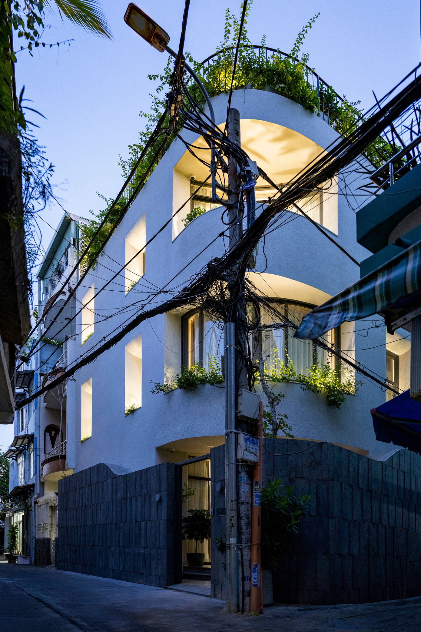 Nhìn từ bên ngoài, sự tương tác giữa các đường cong lồi và lõm cùng với các cửa đi, cửa sổ tích hợp khéo léo với các bồn cây âm tường tạo nên một hình khối kiến trúc độc đáo mang tính điêu khắc, đồng thời đảm bảo tính riêng tư và khả năng thông thoáng, lấy sáng tự nhiên của ngôi nhà. Nhìn từ bên ngoài, sự tương tác giữa các đường cong lồi và lõm cùng với các cửa đi, cửa sổ tích hợp khéo léo với các bồn cây âm tường tạo nên một hình khối kiến trúc độc đáo mang tính điêu khắc, đồng thời đảm bảo tính riêng tư và khả năng thông thoáng, lấy sáng tự nhiên của ngôi nhà.