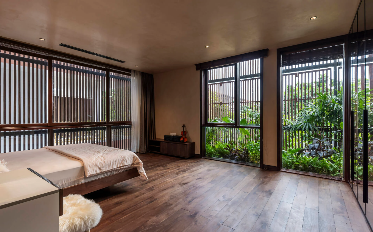 Phía ngoài phòng ngủ được bảo vệ bởi hệ lam gỗ, giúp điều tiết ánh sáng và tăng tính riêng tư.