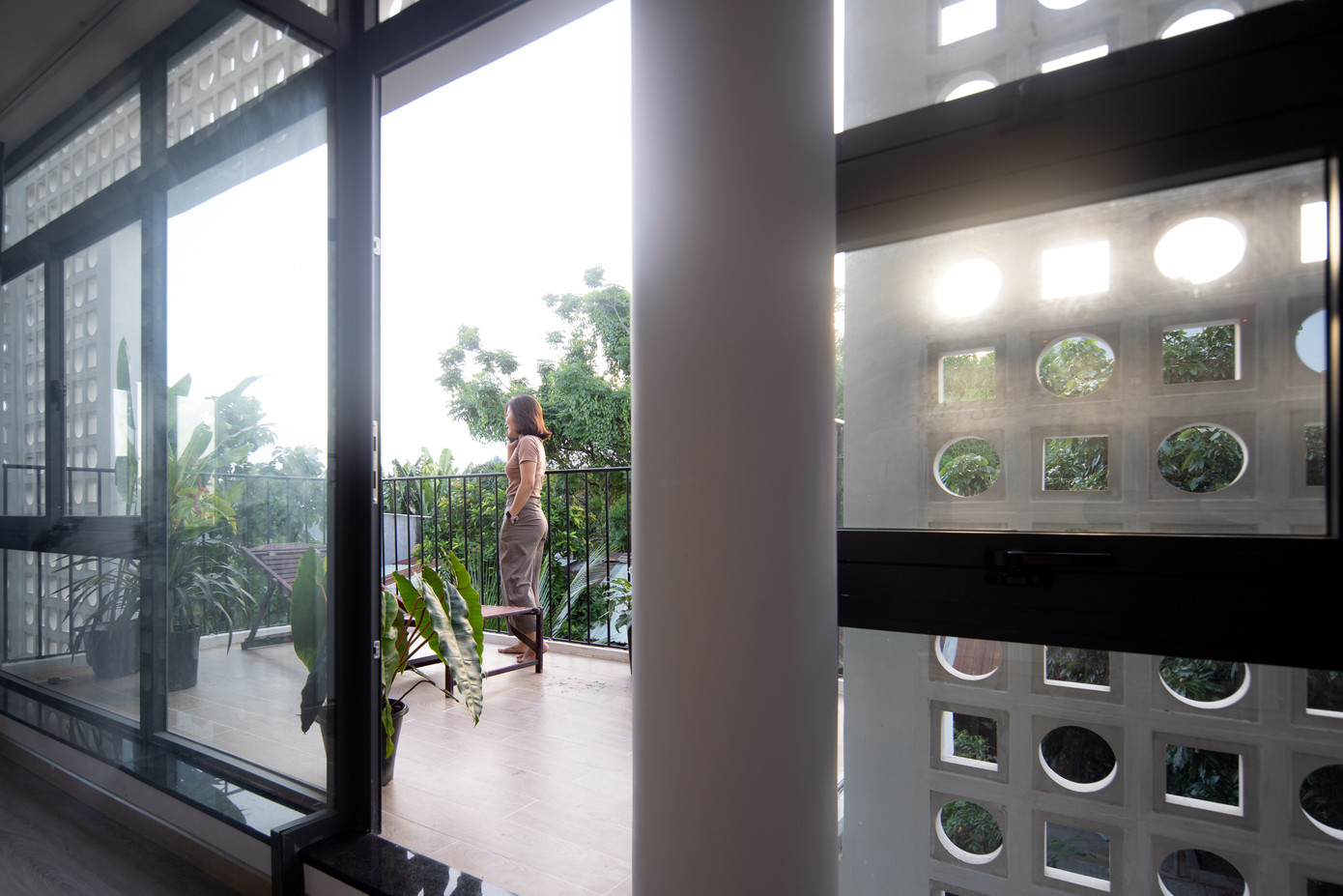 Ánh sáng tự nhiên tràn vào từ lớp cửa kính và gạch hoa gió.