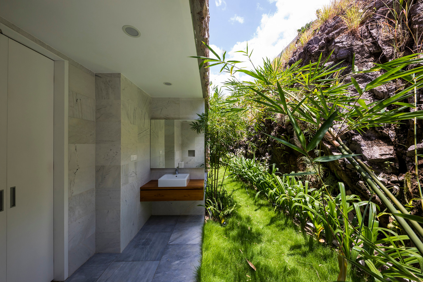 Căn nhà có hai yếu tố chính: một trần nhà rất cao, tráng men ở phía trước, ốp đá phía sau, nhìn về phía biển và đồi, và một hộp gỗ có cửa chớp lớn có thể mở được. Do có vách đá ở phía sau và tầng 1 thấp, căn nhà trải theo chiều dọc.