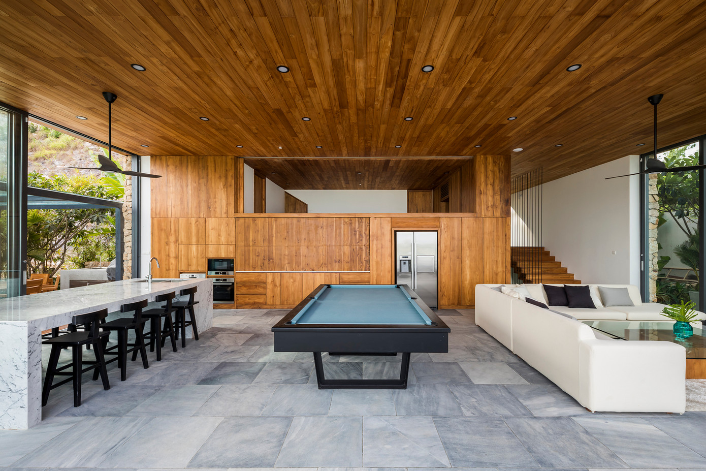 Sàn boong là không gian chính nơi phòng ăn, bếp và phòng ngủ hợp thành một không gian duy nhất kết nối liền mạch với không gian ngoài trời. Trần cao có một gác lửng, với dãy phòng ngủ nhìn ra nhà bếp. Hộp gỗ chứa tầng một với hai dãy phòng ngủ.