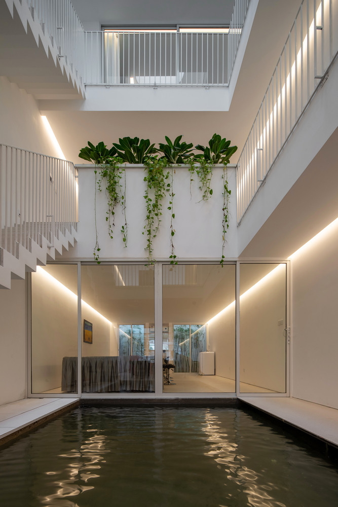 Có một ao làm mát ở mặt đất, và một cửa sổ trên mái lớn trực tiếp phía trên ao, mang đến nhiều ánh sáng cho không gian và trải nghiệm sự chuyển đổi không gian và thời gian khi một người đi bộ trong suốt một ngày.