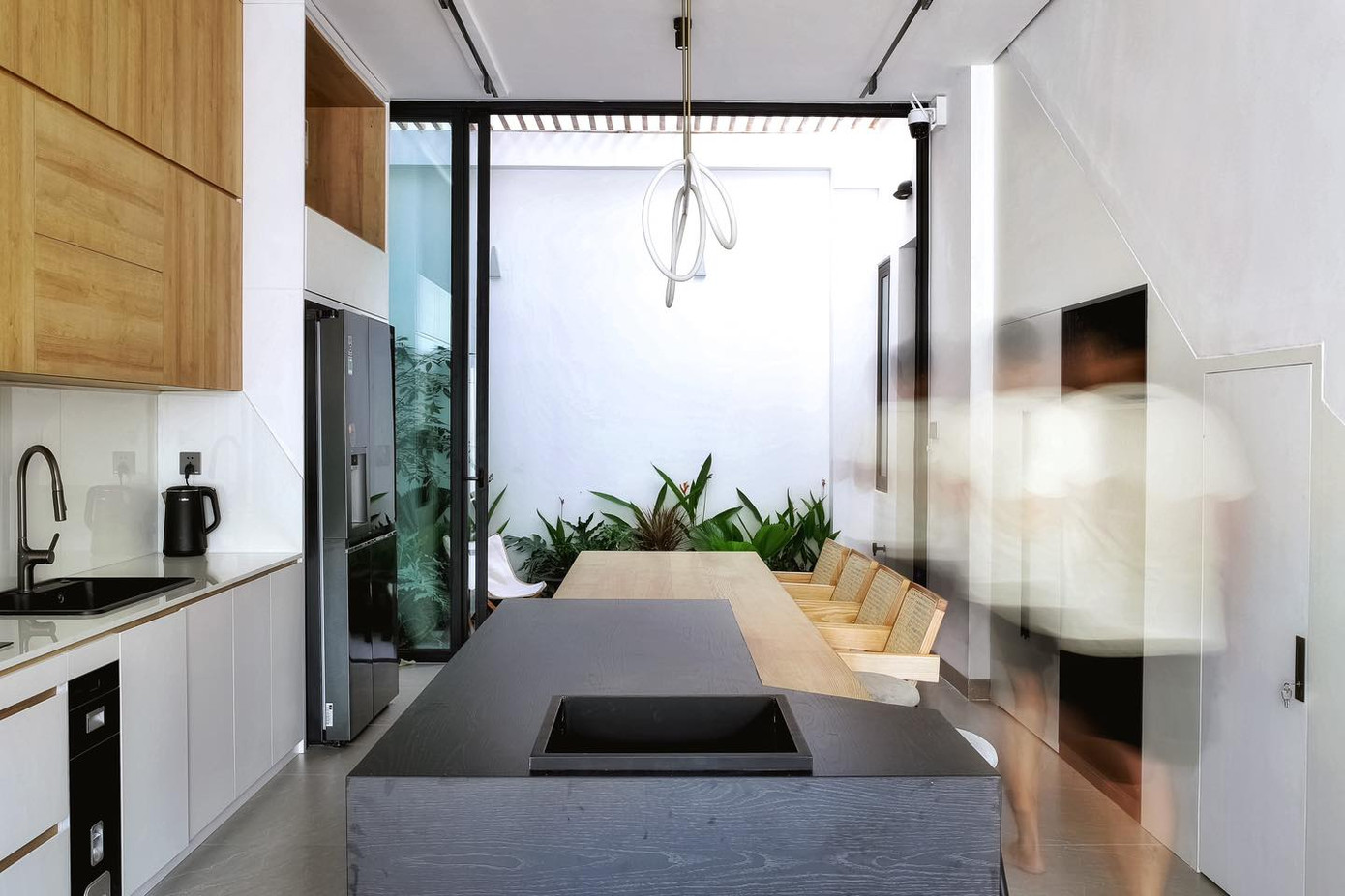 Phòng bếp tầng 1 nối với khoảng sân vườn nhỏ phía sau.