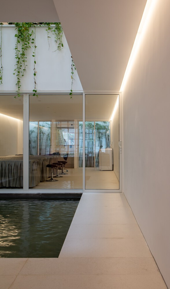 Có một ao làm mát ở mặt đất, và một cửa sổ trên mái lớn trực tiếp phía trên ao, mang đến nhiều ánh sáng cho không gian và trải nghiệm sự chuyển đổi không gian và thời gian khi một người đi bộ trong suốt một ngày.