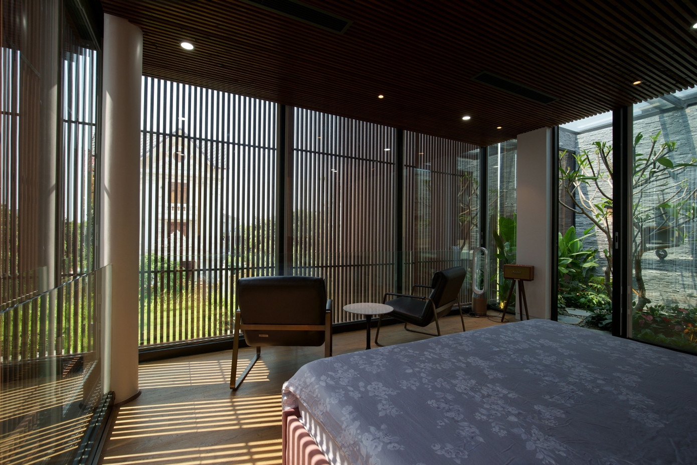 Phòng ngủ được bao bọc bởi kính và lớp lam gỗ chống nắng.