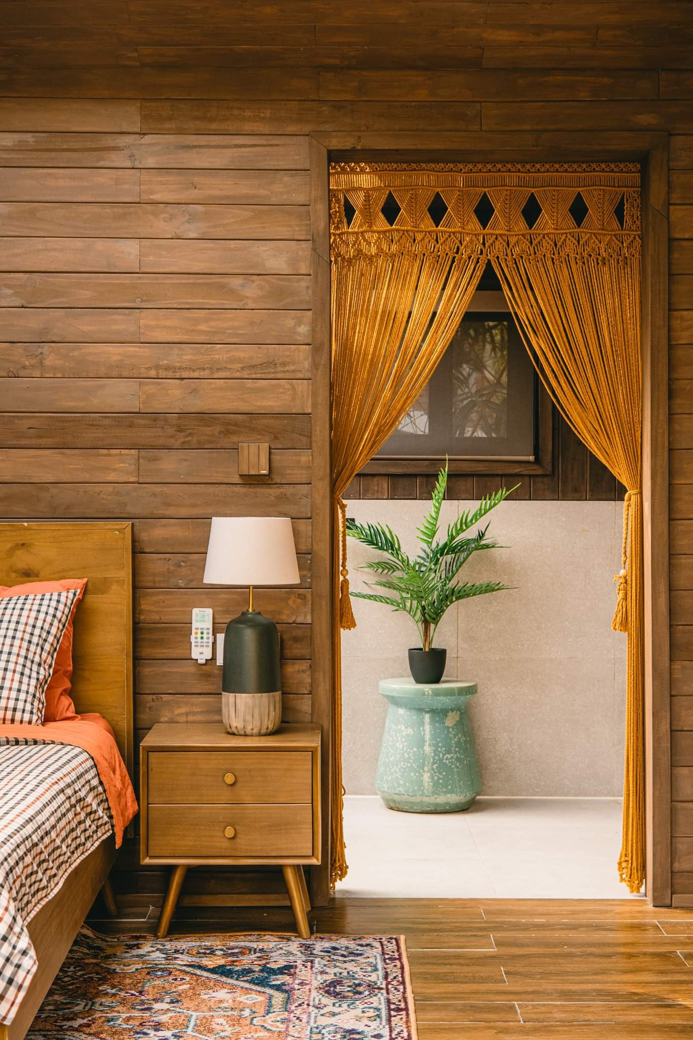 Thảm họa tiết thổ cẩm quanh giường ngủ làm không gian thêm đầm ấm.