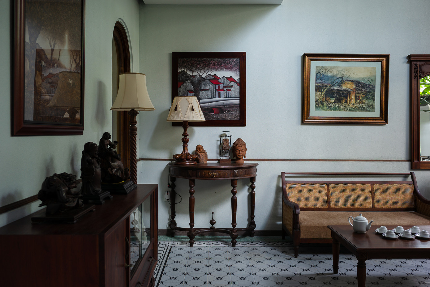 Phòng khách mang đậm hơi thở Đông Dương với nội thất gỗ, tượng điêu khắc, gạch bông lót sàn, con tiện, tranh sơn dầu, đèn chụp kiểu Pháp....
