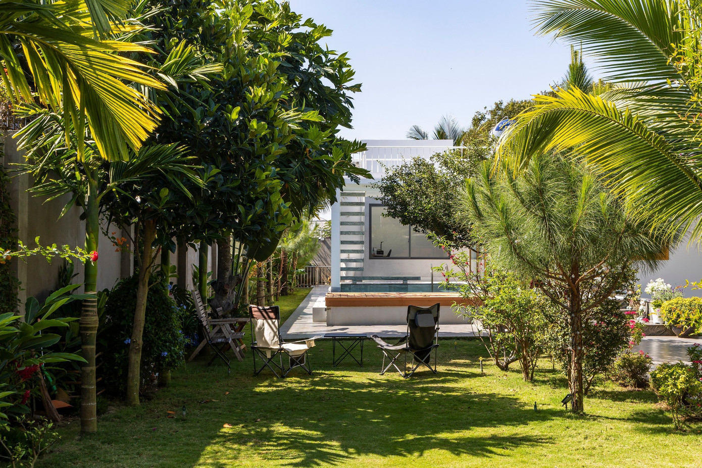 Bên ngoài xanh mát với bóng cây và hàng hoa giấy rực rỡ.