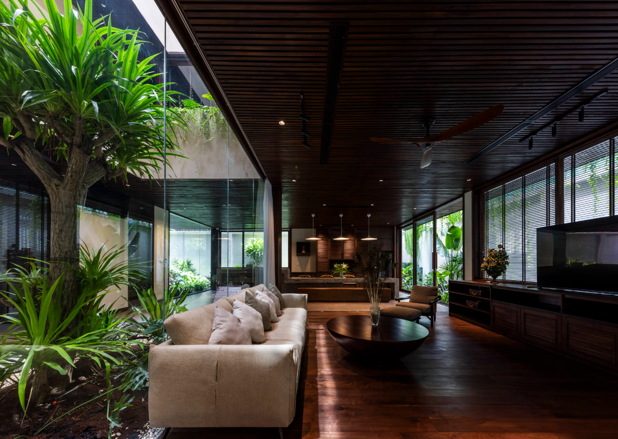 Phòng khách ngăn cách với khu vườn qua một lớp tường kính trong suốt.