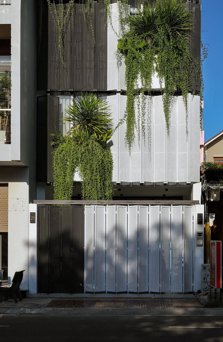 Mặt tiền chính của căn nhà có lớp Lam Sắt là điểm nhấn, kết hợp với cây xanh tạo không gian thoáng đãng, mát mẻ.