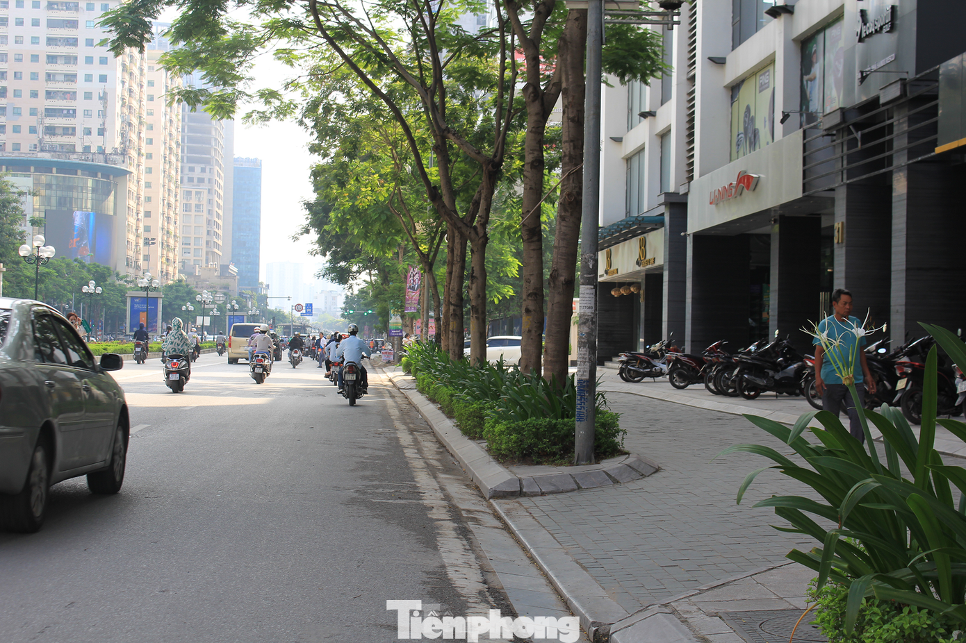 Nhiều dự án chung cư trên đường Lê Văn Lương (quận Thanh Xuân) tự ý san hạ cốt nền vỉa hè để làm lối đi riêng cho ô tô và xe máy vào tòa nhà. (Ảnh: Lập Đông)