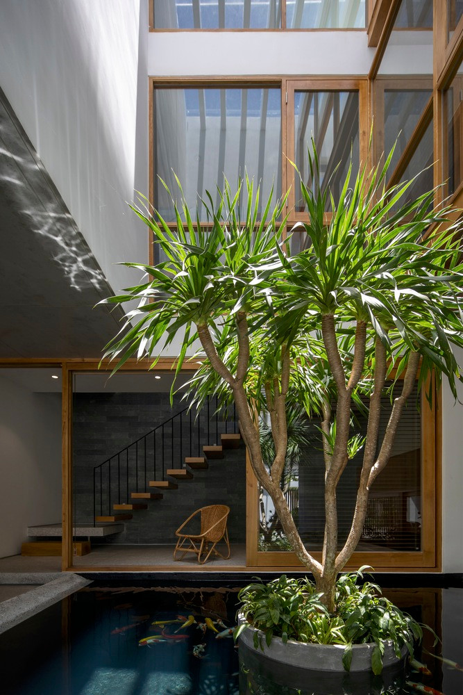 Ngôi nhà có kết cấu 3 tầng, tầng 1 làm văn phòng, tầng 2 và 3 dành cho không gian sinh hoạt của gia đình. Để không gian sống trở nên nhẹ nhàng và thân mật hơn, kiến trúc sư sử dụng những vật liệu tối giản và đồng nhất, tương phản với những bức tường trắng là đồ nội thất bằng gỗ tự nhiên.