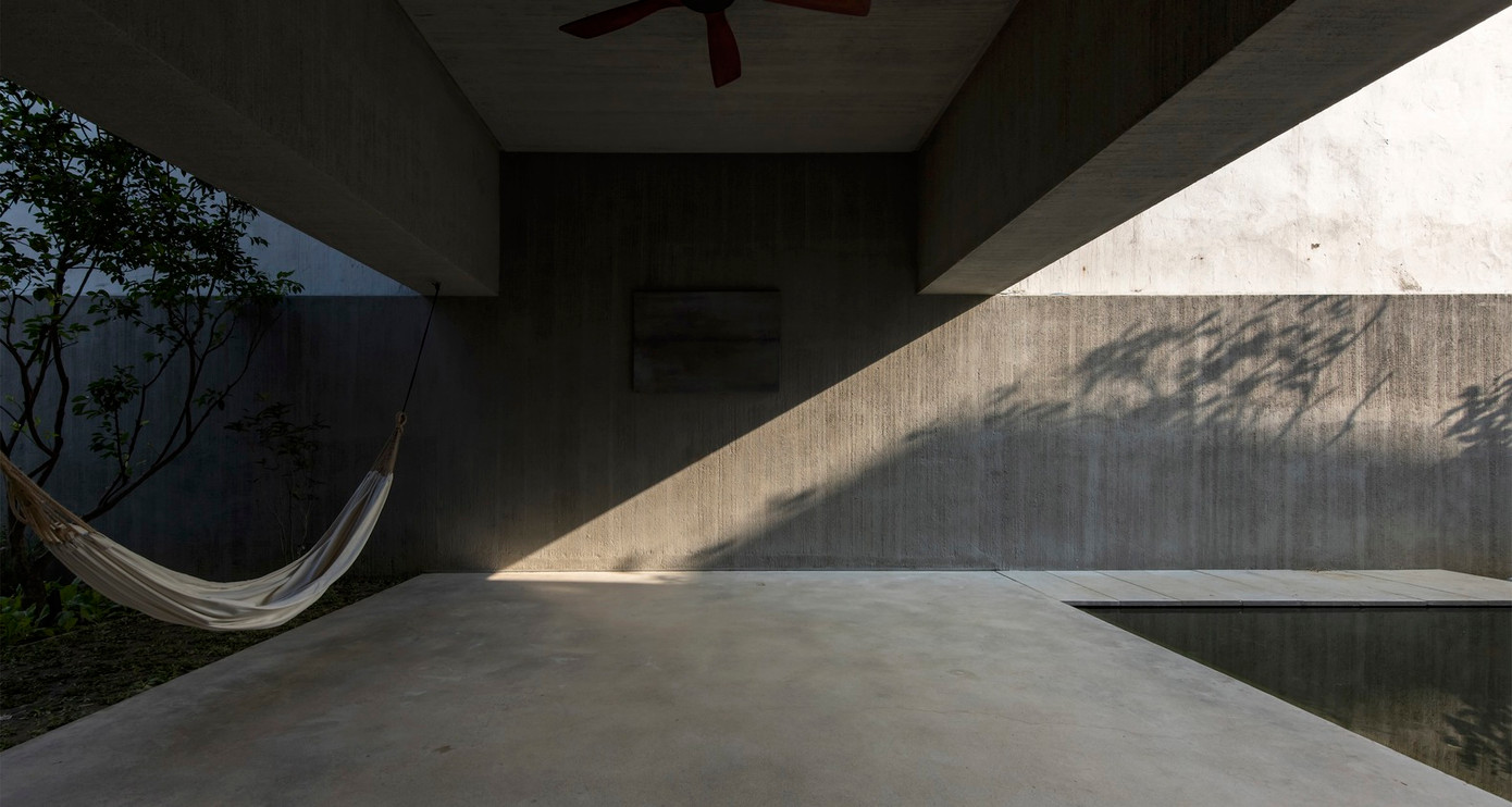 Nền bê tông đánh bóng bằng sáp trong, tường và trần nhà được cào xước trước khi sơn chống thấm gốc xi măng xám, đồ nội thất bằng gỗ để ngôi nhà mang không khí bình yên và xưa cũ.