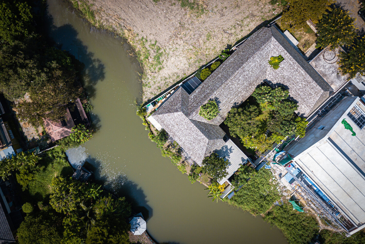 Kiến trúc sư đã thiết kế mặt bằng hình chữ U, mặt thoáng hướng về phía Bắc nơi có con sông chảy qua để giúp ngôi nhà luôn thoáng mát và sử dụng bóng râm của cây cối để ngụy trang cho không gian nội thất riêng tư hơn.