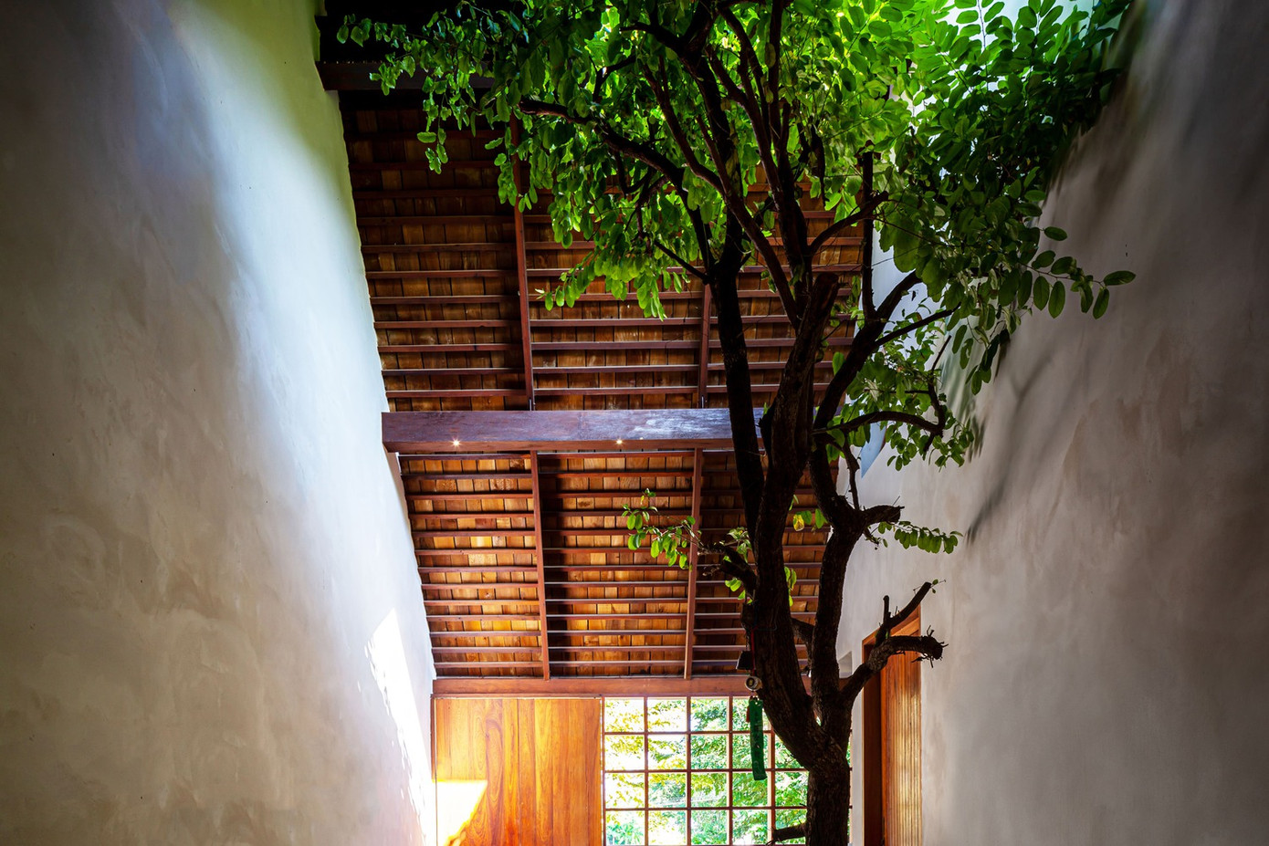 Để tiết kiệm chi phí và thân thiện với môi trường xung quanh, kiến trúc sư kết hợp thạch cao và gỗ để xây dựng nên những bức tường bán kiên cố để che chắn không gian khỏi ánh nắng trực tiếp và cho phép gió, ánh sáng đi xuyên vào bên trong nhà.