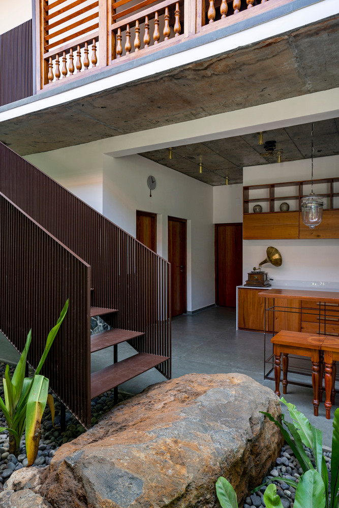 Những tảng đá tự nhiên lớn được đặt trong sân với cầu thang nổi phía trên và cây xanh xung quanh để khoảng sân trở thành tâm điểm.