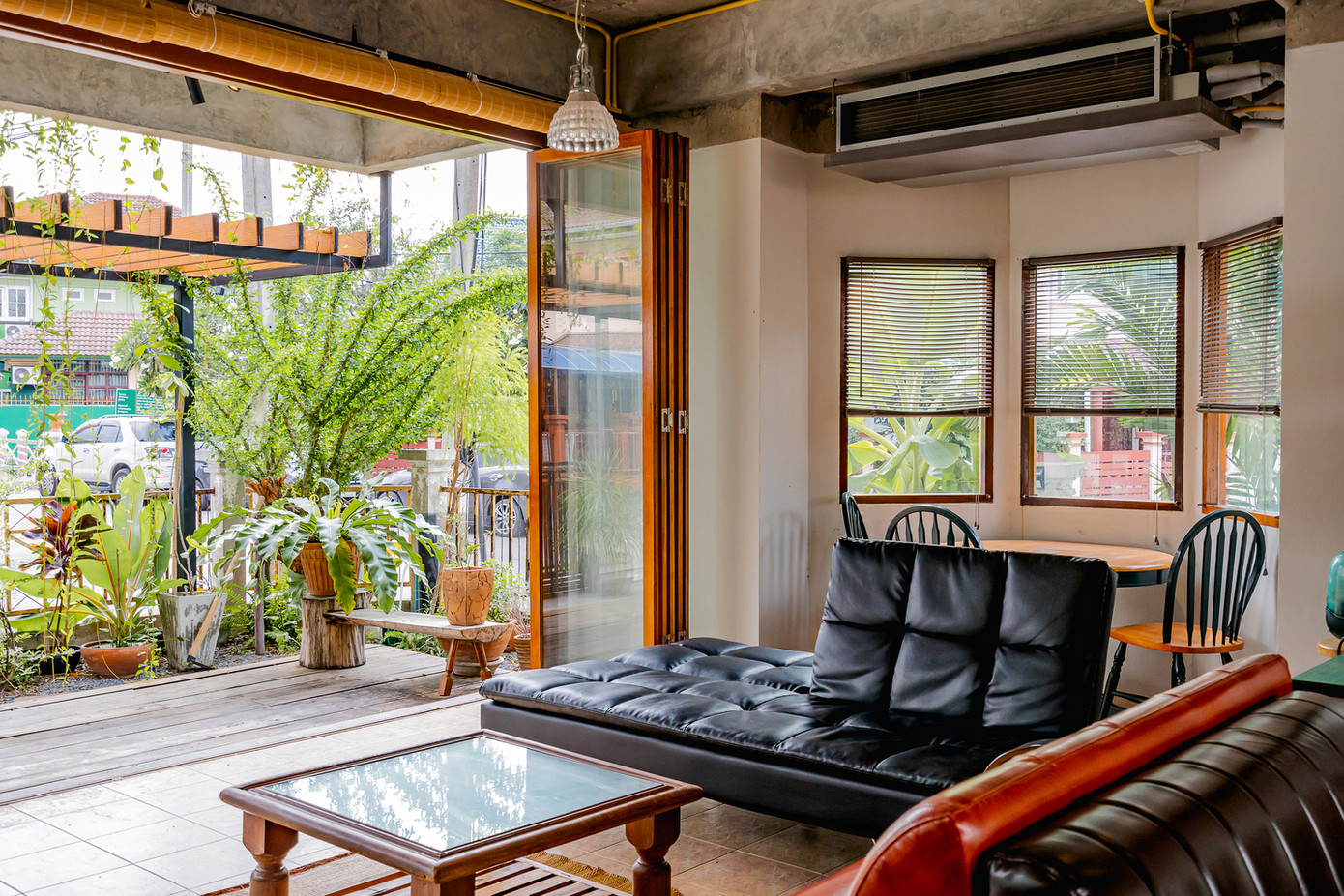 Không gian phòng khách rộng mở, tràn ngập ánh sáng và khí trời. Xen kẽ giữa các mảng tường là màu xanh của cây cối.