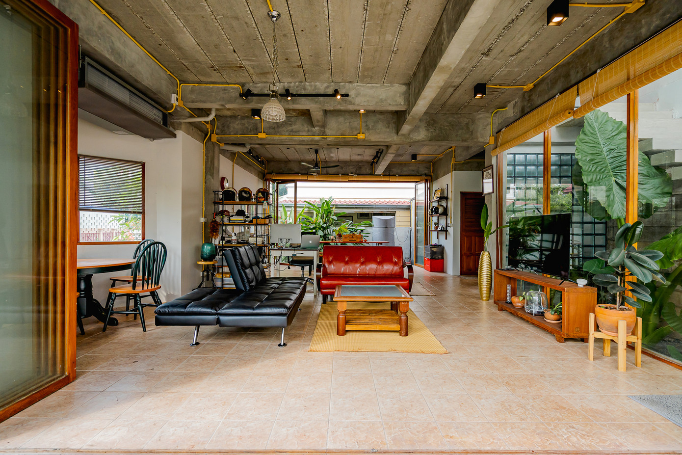 Không gian phòng khách rộng mở, tràn ngập ánh sáng và khí trời. Xen kẽ giữa các mảng tường là màu xanh của cây cối.