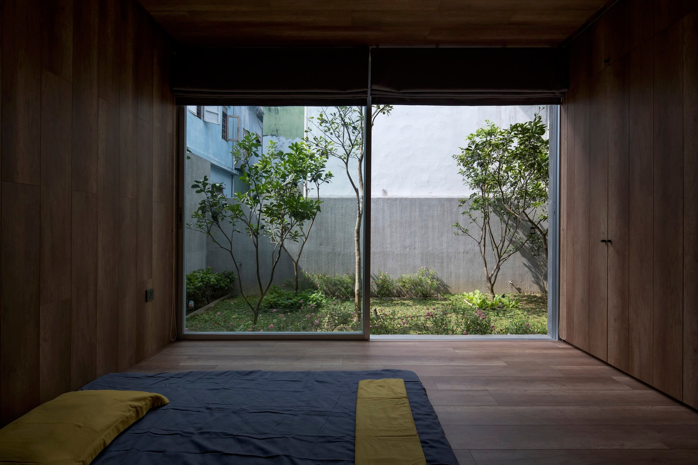 Nền bê tông đánh bóng bằng sáp trong, tường và trần nhà được cào xước trước khi sơn chống thấm gốc xi măng xám, đồ nội thất bằng gỗ để ngôi nhà mang không khí bình yên và xưa cũ.