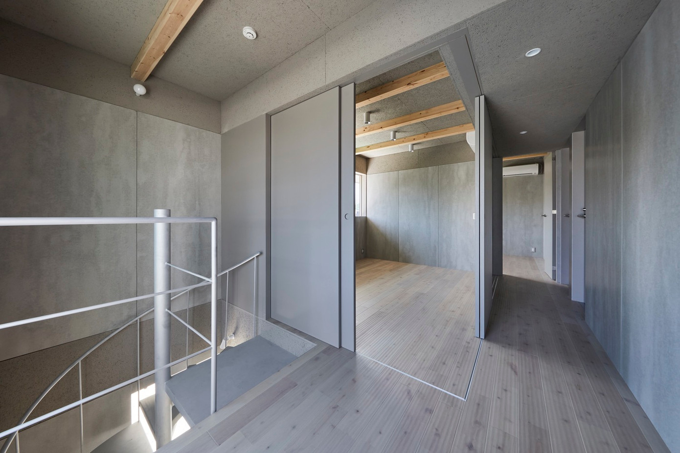 Sự kết hợp giữa vật liệu gỗ với các bảng tường bê tông màu xám tưởng như khác biệt lại giúp ngôi nhà có một không gian đồng nhất và ấn tượng.