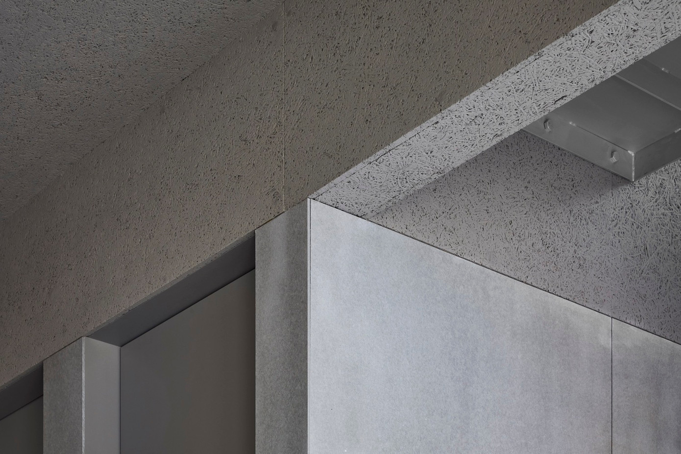 Sự kết hợp giữa vật liệu gỗ với các bảng tường bê tông màu xám tưởng như khác biệt lại giúp ngôi nhà có một không gian đồng nhất và ấn tượng.