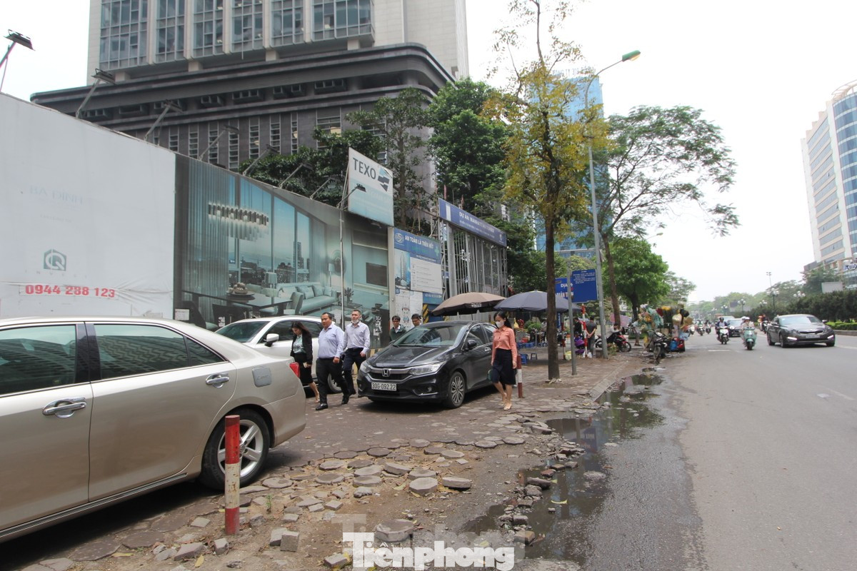 Nhiều dự án chung cư trên đường Lê Văn Lương (quận Thanh Xuân) tự ý san hạ cốt nền vỉa hè để làm lối đi riêng cho ô tô và xe máy vào tòa nhà. (Ảnh: Lập Đông)