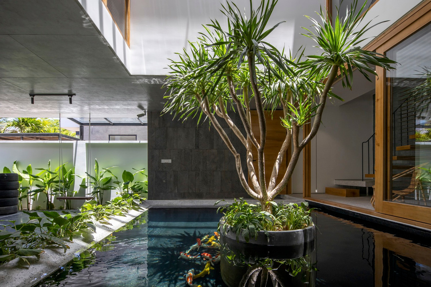 Mọi sinh hoạt của gia đình và công việc văn phòng bên trong ngôi nhà đều xoay quanh sân trong với giếng trời, hồ nước tiểu cảnh và cây xanh ở trung tâm.