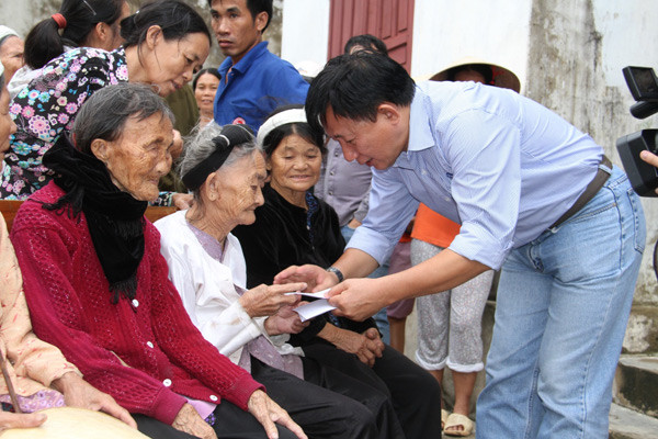 Ông Nguyễn Thanh Tú, đại diện đoàn công tác ân cần thăm hỏi và trao quà cho các cụ cao niên tại TX.Hoàng Mai (Nghệ An)