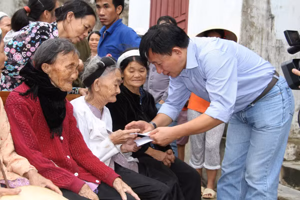 Ông Nguyễn Thanh Tú, đại diện đoàn công tác ân cần thăm hỏi và trao quà cho các cụ cao niên tại TX.Hoàng Mai (Nghệ An)