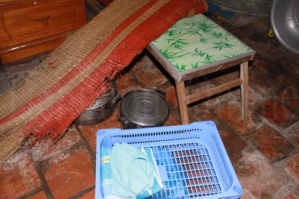 Ngoài ra còn một chiếc chạn nhựa được hàng xóm cho, một chiếc chiếu đã thủng, một chiếc bàn học đã cũ. Ảnh: Trường Phong