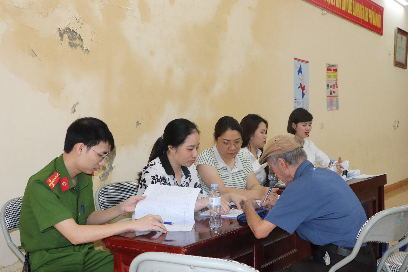 Cán bộ công an phối hợp cơ quan BHXH Hưng Yên hướng dẫn người dân nhận lương hưu, trợ cấp BHXH trên nền cơ sở dữ liệu quốc gia về dân cư.