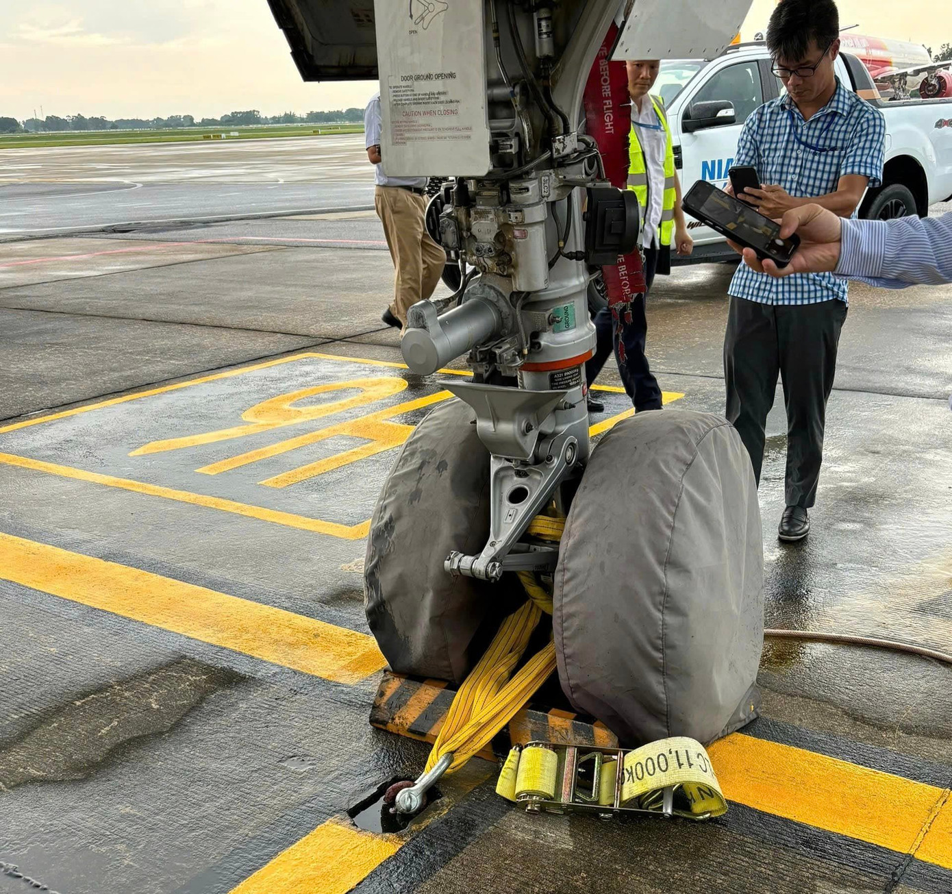 Các kỹ sư dùng dây giữ chặt càng tàu bay bằng 4 móc sắt dưới mặt đất và dùng các khối bêtông hoặc bơm dầu đầy vào hai cánh tạo sức nặng cho máy bay. Ảnh NIA. Các kỹ sư dùng dây giữ chặt càng tàu bay bằng 4 móc sắt dưới mặt đất và dùng các khối bêtông hoặc bơm dầu đầy vào hai cánh tạo sức nặng cho máy bay. Ảnh NIA.