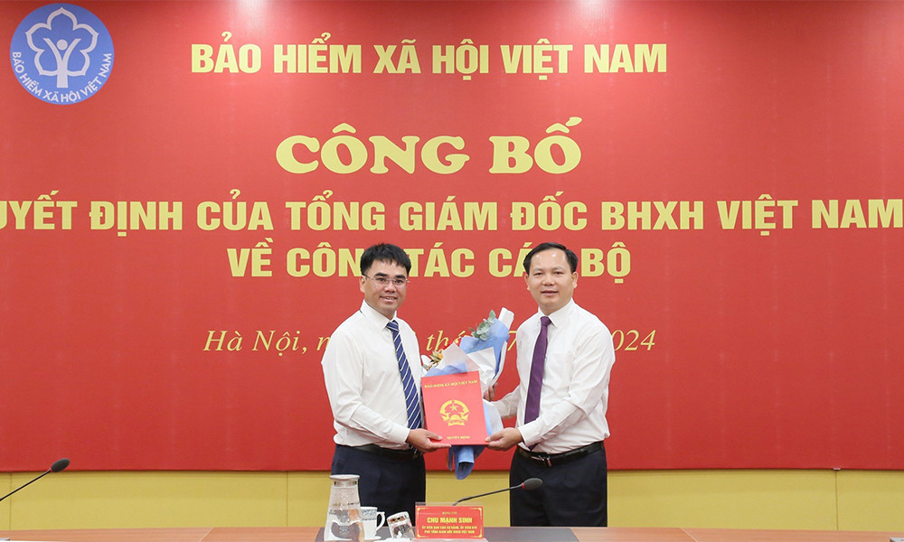 Phó Tổng giám đốc BHXH Việt Nam Chu Mạnh Sinh (bên phải) trao quyết định cho tân Vụ trưởng Vụ Kiểm toán nội bộ.